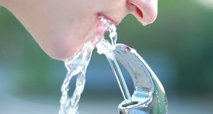 Woman drinking water from fountain
