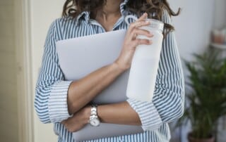 woman in white and blue stripe shirt holding white ceramic mug